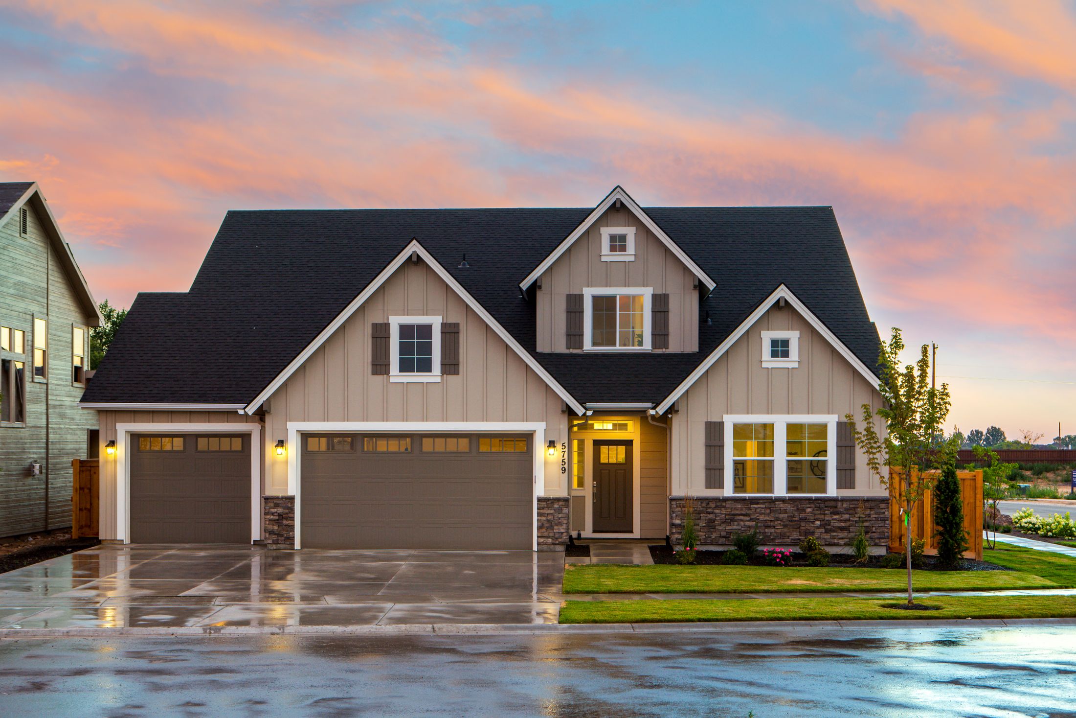 Welcoming two-story home with warm lighting and a landscaped yard